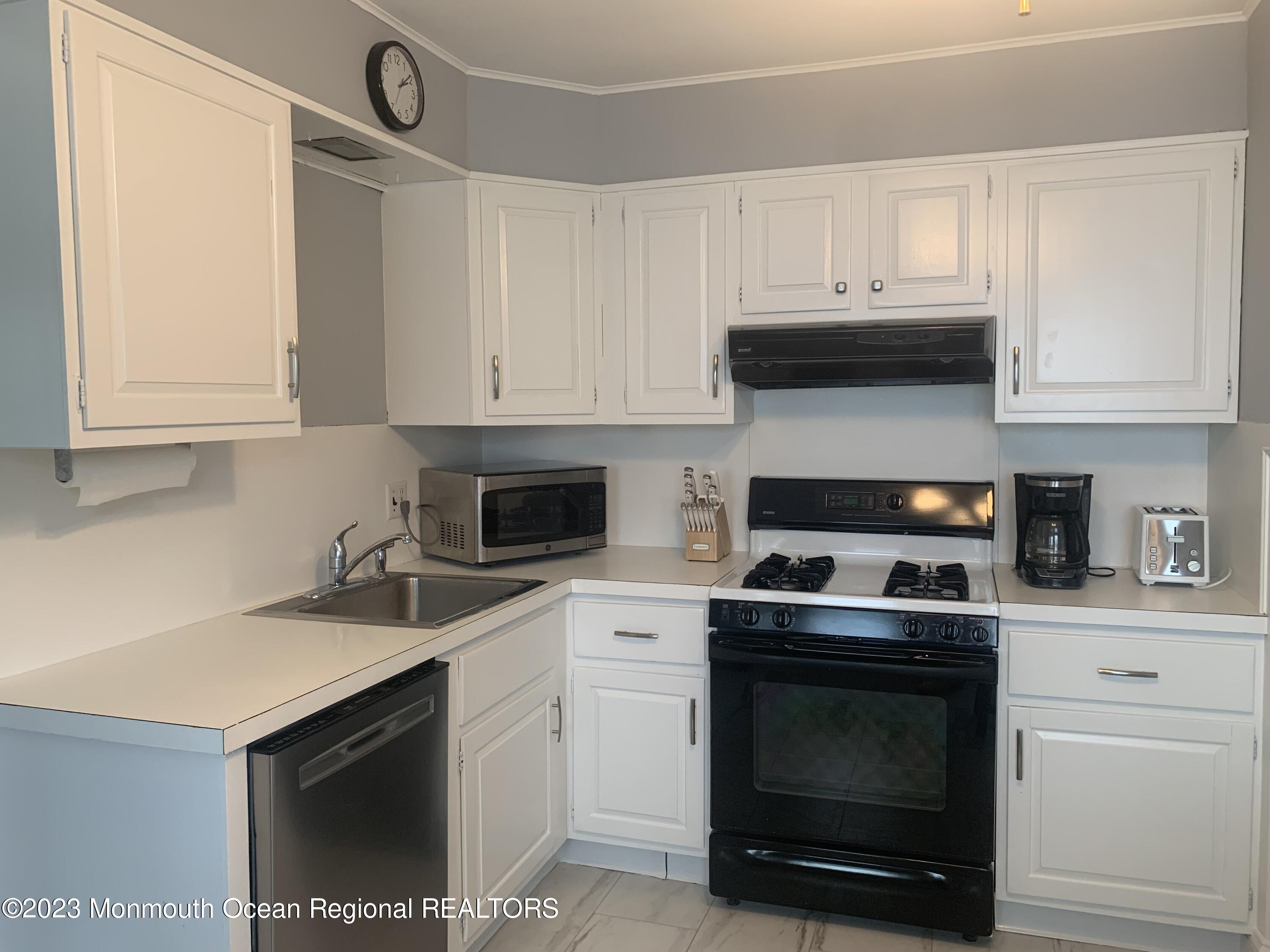 312 Salem Avenue Spring Lake, NJ 07762 - Photo 4 of 18 a kitchen with white cabinets and appliances