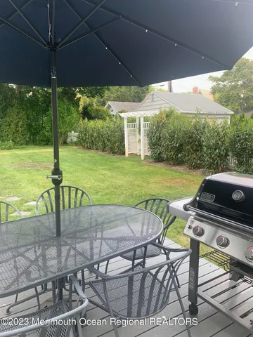 a view of a patio with table and chairs under an umbrella
