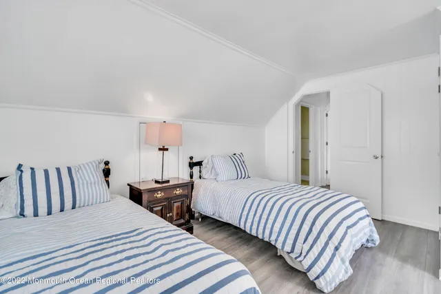 a bedroom with two beds and wooden floor