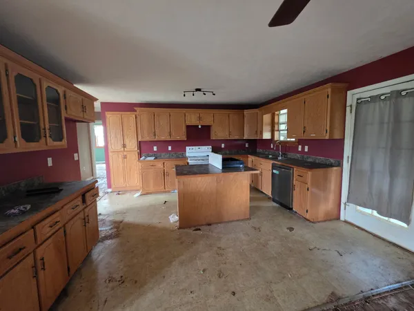 a kitchen with stainless steel appliances wooden cabinets a stove top oven a sink and dishwasher