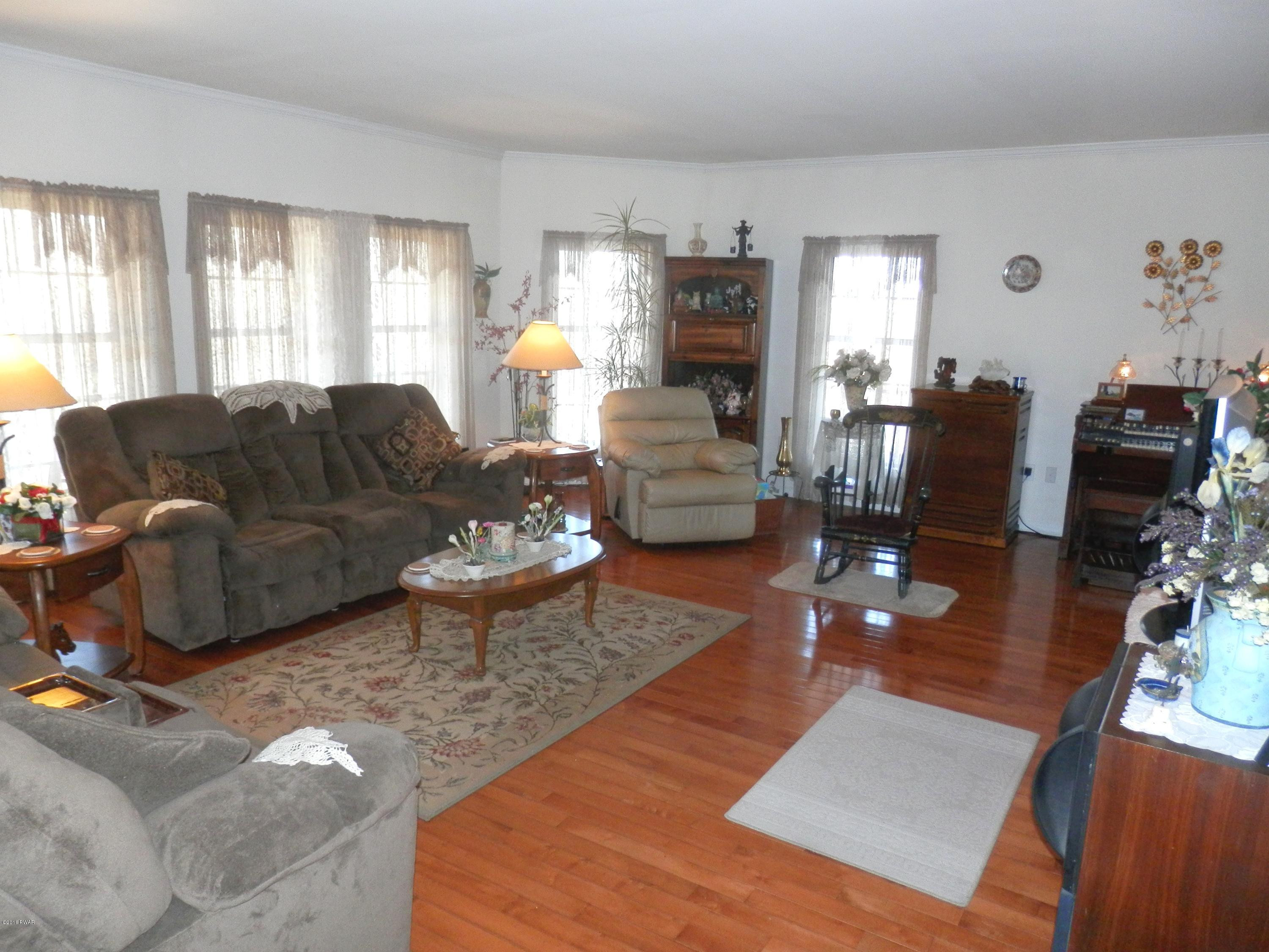 176 Highland Road Pleasant Mount, PA 18453 - Photo 16 of 52 a living room with furniture wooden floor and a large window