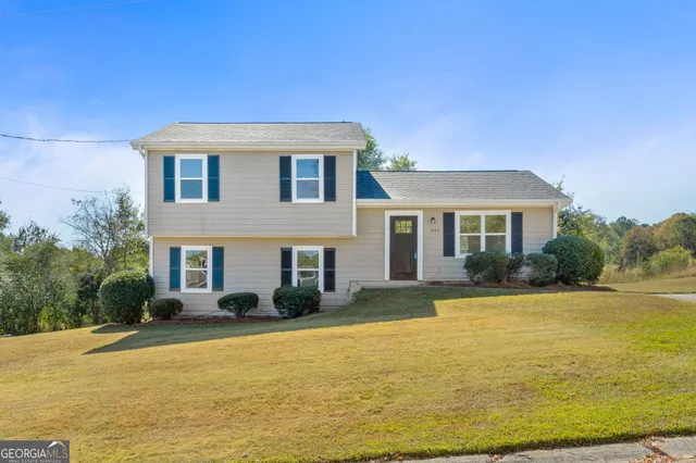 a white house with a large pool in front of it