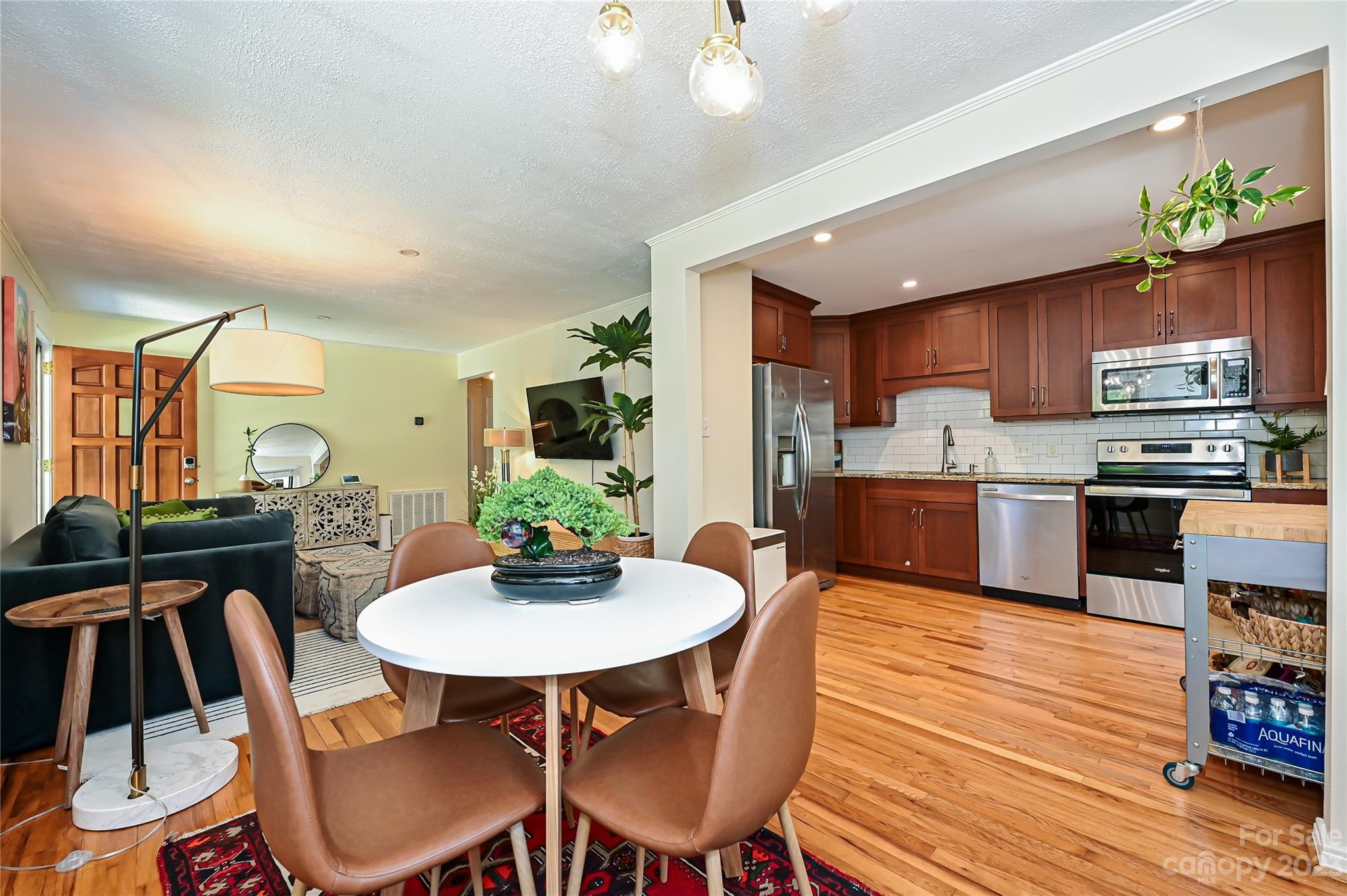 4609 Murrayhill Road Charlotte, NC 28209 - Photo 15 of 38 a kitchen with stainless steel appliances kitchen island granite countertop a kitchen island hardwood floor sink stove dining table and chairs
