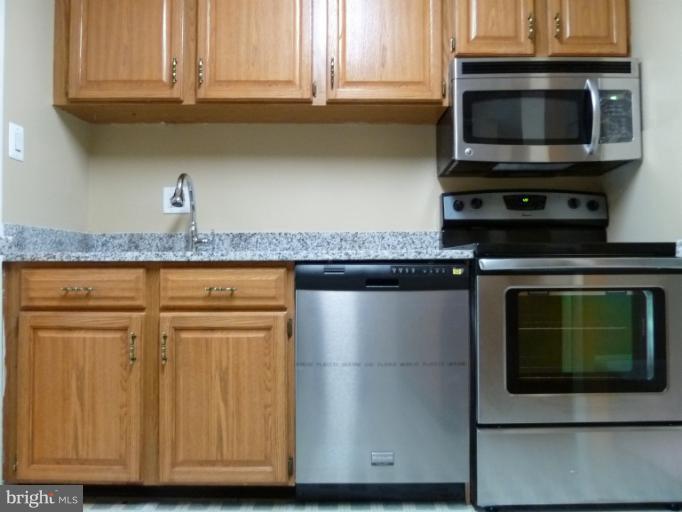 1782 Ivy Oak Square, Unit 79 Reston, VA 20190 - Photo 14 of 23 a kitchen with granite countertop cabinets stainless steel appliances and wooden cabinets