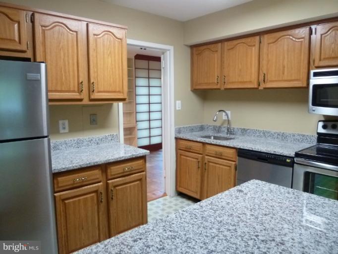 1782 Ivy Oak Square, Unit 79 Reston, VA 20190 - Photo 10 of 23 a kitchen with stainless steel appliances granite countertop a refrigerator sink and cabinets