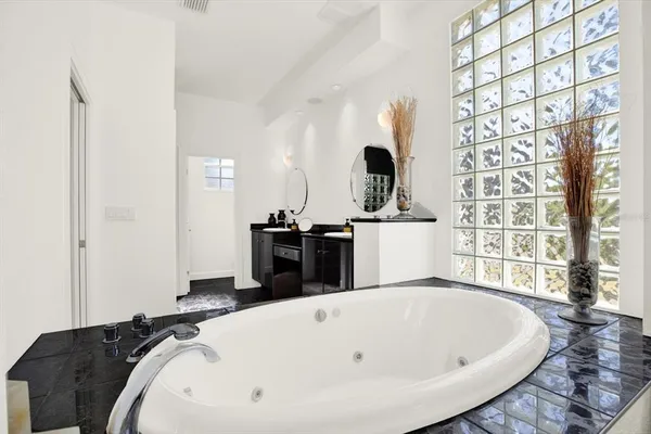 a large white bed sitting in a kitchen next to a window