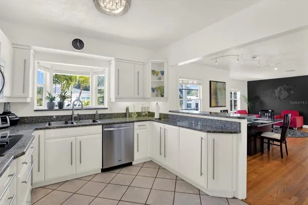 a kitchen with white cabinets and sink