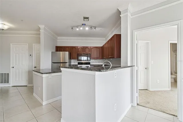 a kitchen with stainless steel appliances granite countertop a refrigerator and a stove top oven