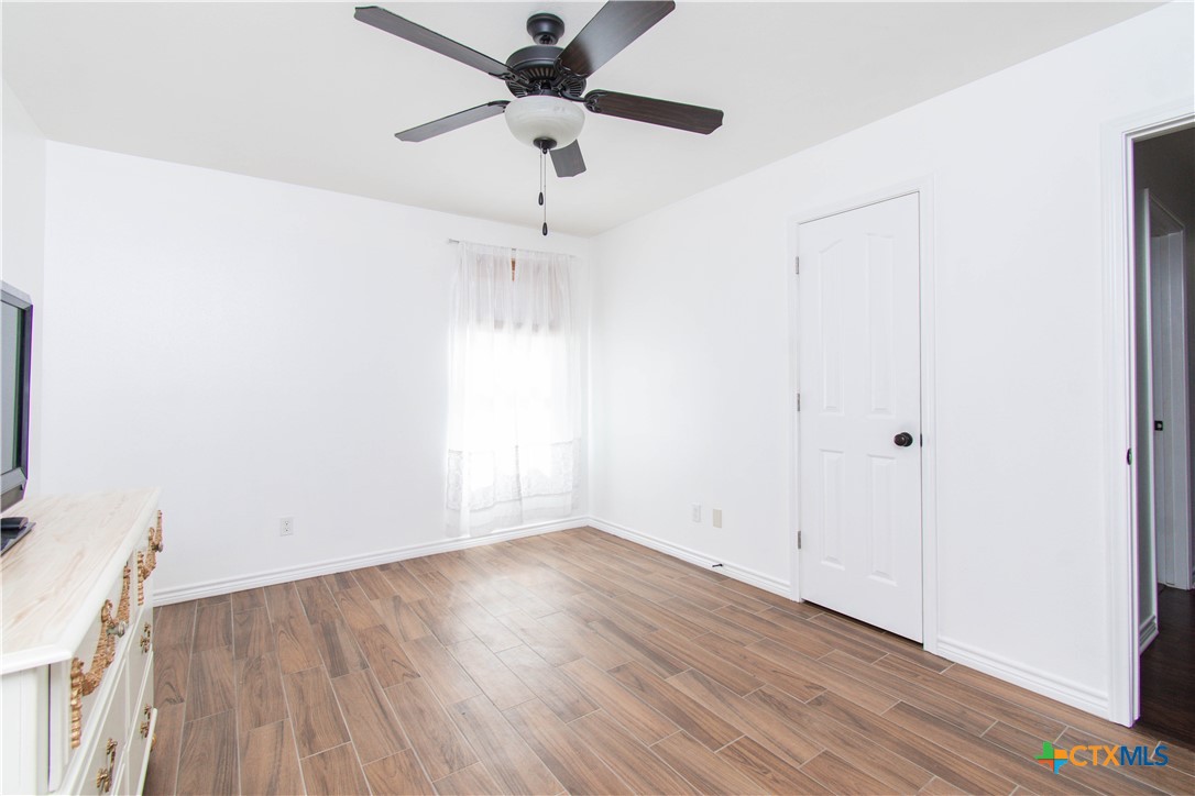 519 Pleasant View Road Troy, TX 76579 - Photo 17 of 30 an empty room with wooden floor fan and windows