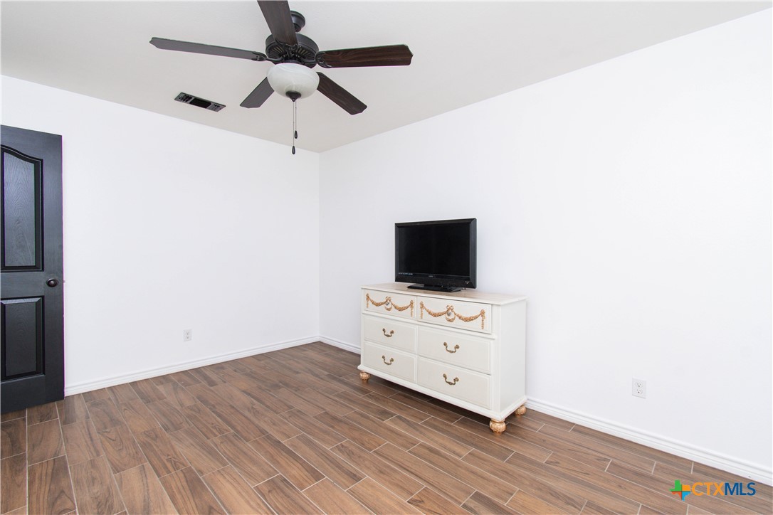 519 Pleasant View Road Troy, TX 76579 - Photo 18 of 30 a room with a flat screen tv dressers and a ceiling fan