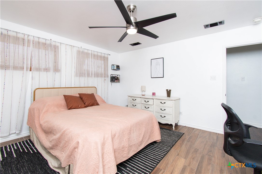 519 Pleasant View Road Troy, TX 76579 - Photo 20 of 30 a bedroom with a large bed and a chandelier