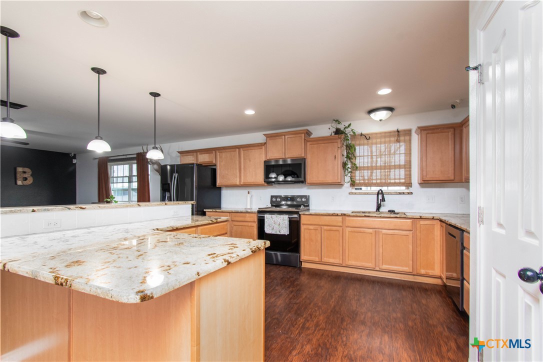 519 Pleasant View Road Troy, TX 76579 - Photo 7 of 30 a large kitchen with kitchen island a stove a sink a center island and wooden floor