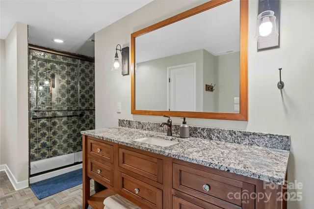 a bathroom with a granite countertop sink and a mirror