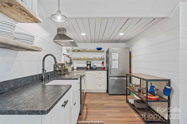 a kitchen with stainless steel appliances granite countertop a sink and a refrigerator