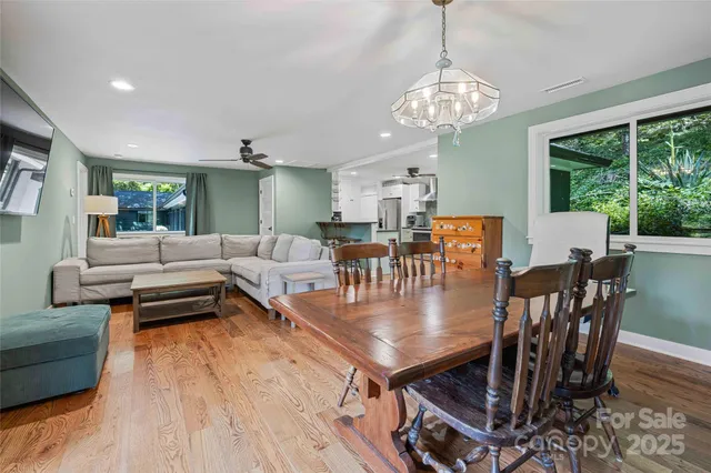 a view of a dining room with furniture a chandelier and wooden floor