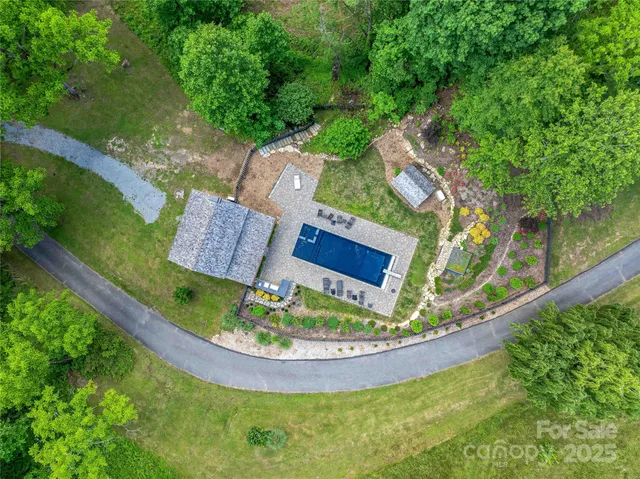 an aerial view of a house a yard and a fountain
