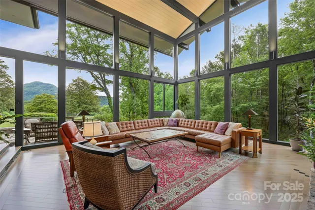 a living room with furniture and floor to ceiling windows