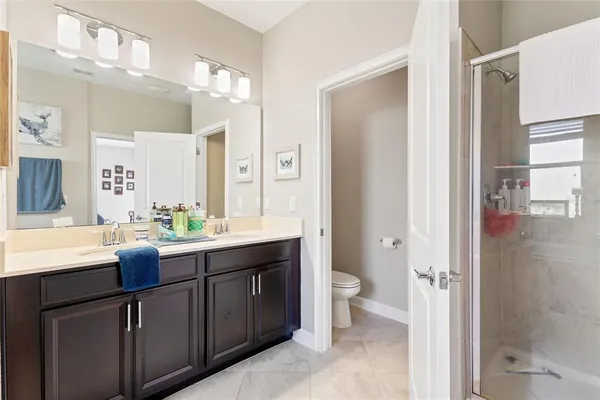 a bathroom with a double vanity sink toilet mirror and bathtub