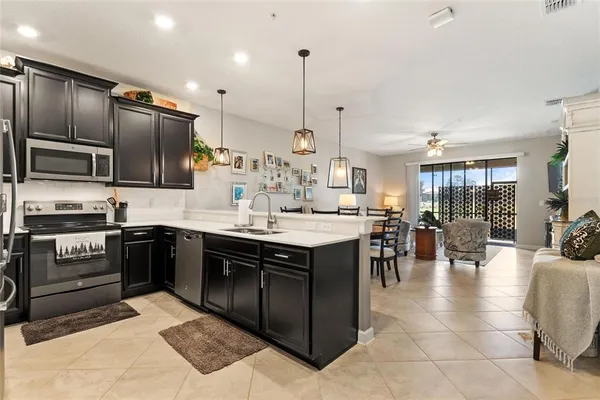 a kitchen with stainless steel appliances granite countertop a stove top oven a sink dishwasher a dining table and chairs