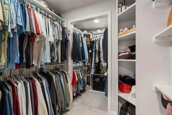 a view of walk in closet with clothes