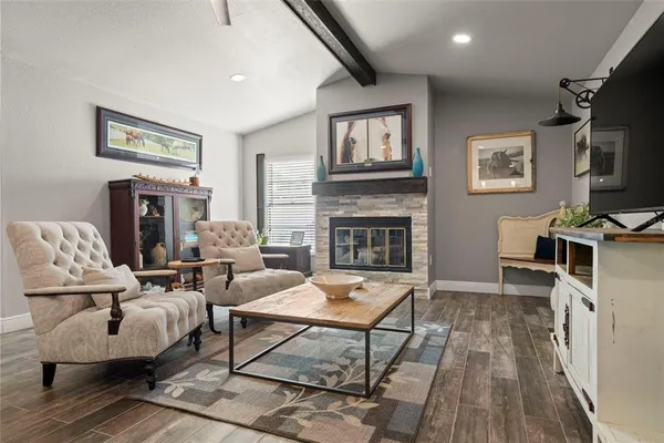 a living room with furniture a flat screen tv and a fireplace