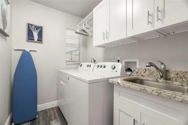 a utility room with sink dryer and washer