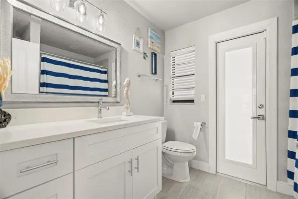 a bathroom with a sink a toilet and a mirror