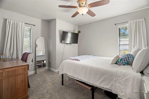 a bedroom with a bed desk and a chair