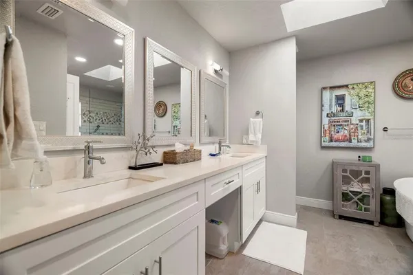 a bathroom with double vanity sinks and a mirror