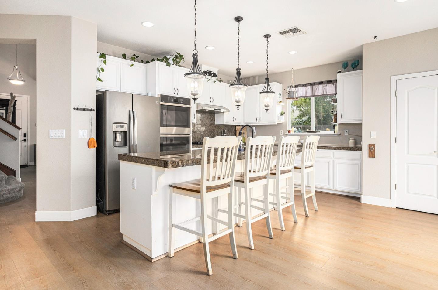 130 Ridge Crest Court Oakley, CA 94561 - Photo 15 of 59 a kitchen with stainless steel appliances kitchen island granite countertop a dining table chairs and white cabinets
