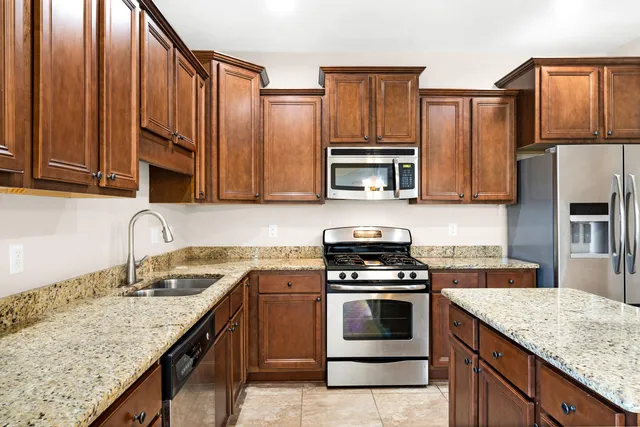 a kitchen with granite countertop stainless steel appliances and wooden cabinets