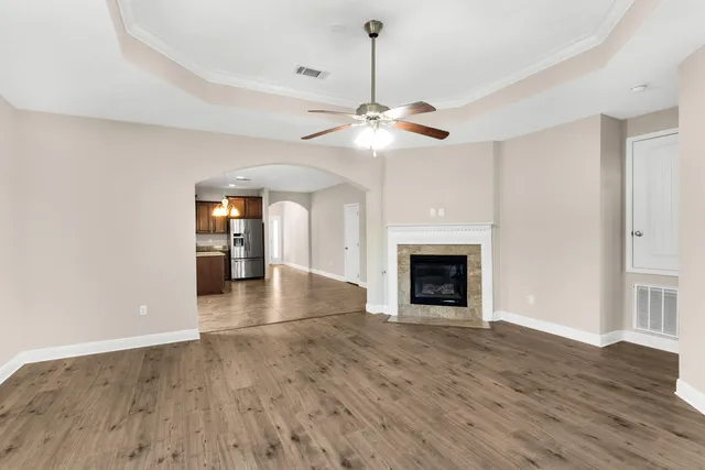 a view of an empty room with a fireplace and a window