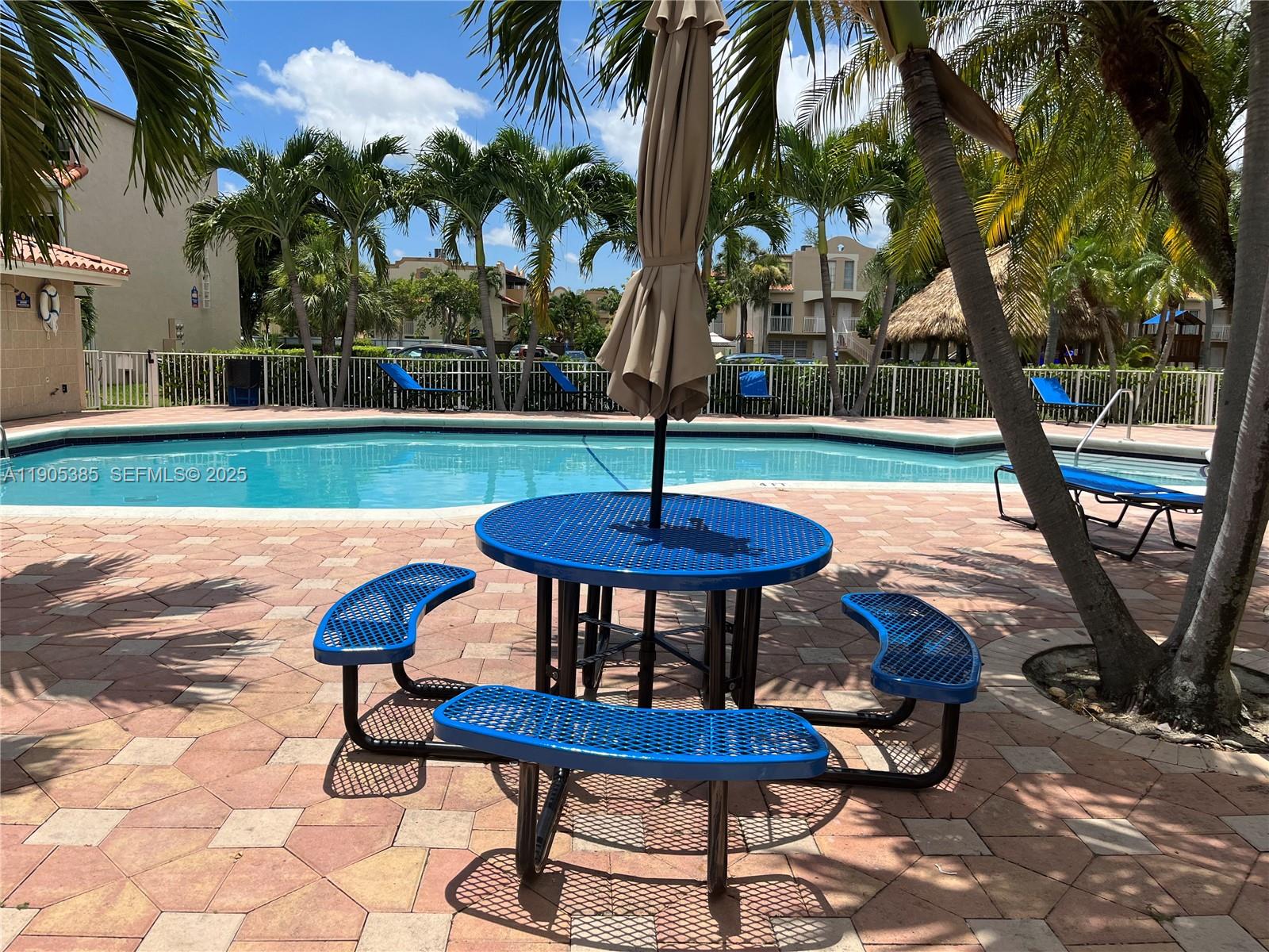 8585 Northwest 6th Lane, Unit 9208 Miami, FL 33126 - Photo 20 of 22 a backyard of a house with table and chairs