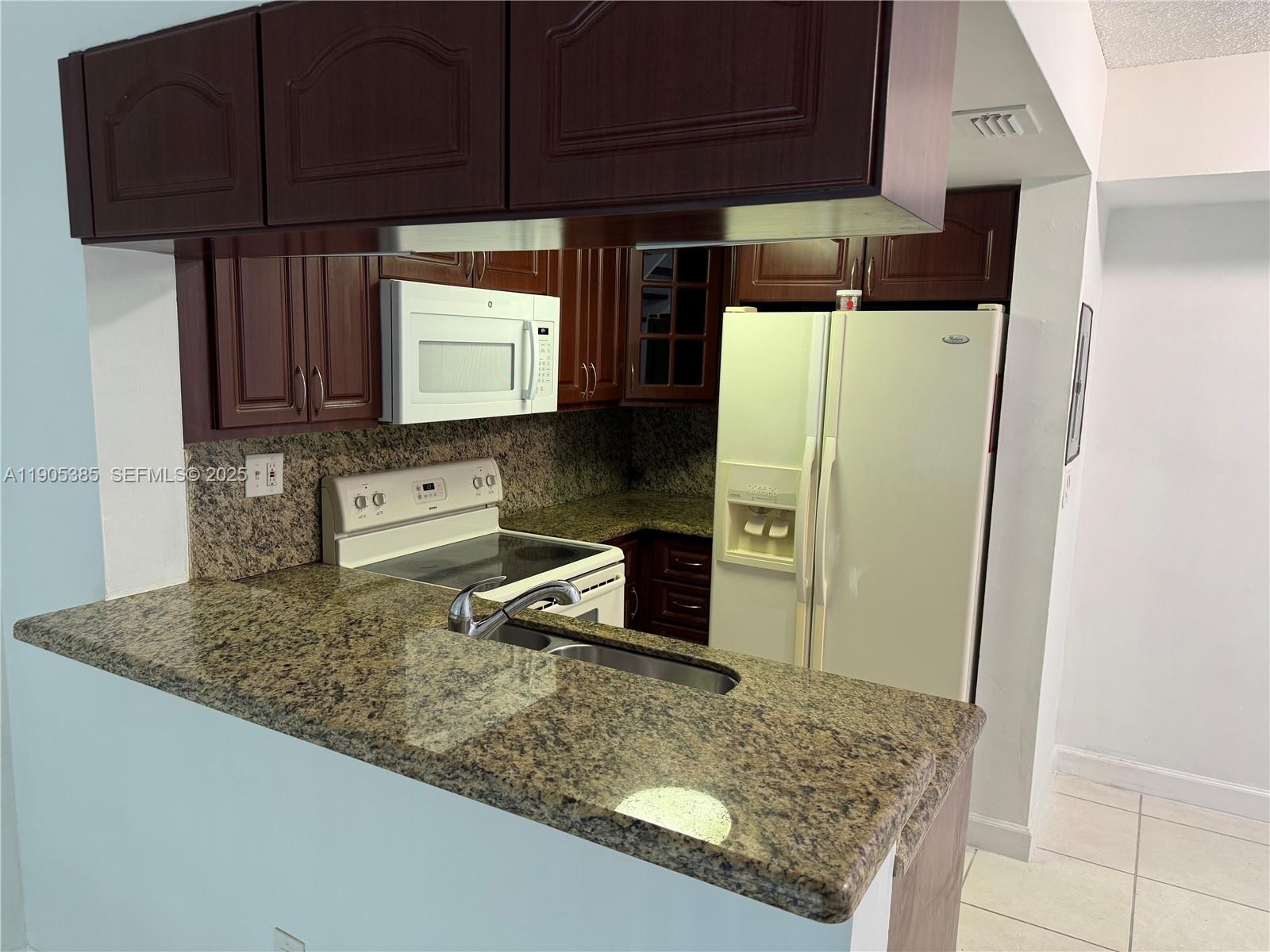 8585 Northwest 6th Lane, Unit 9208 Miami, FL 33126 - Photo 3 of 22 a kitchen with stainless steel appliances granite countertop a refrigerator and a sink