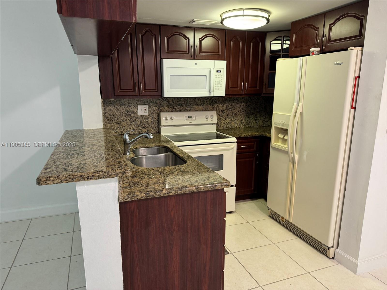 8585 Northwest 6th Lane, Unit 9208 Miami, FL 33126 - Photo 5 of 22 a kitchen with stainless steel appliances granite countertop a refrigerator and a sink
