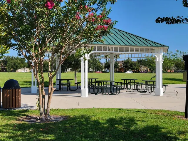 a view of a patio with a table and chairs under an umbrella with a barbeque