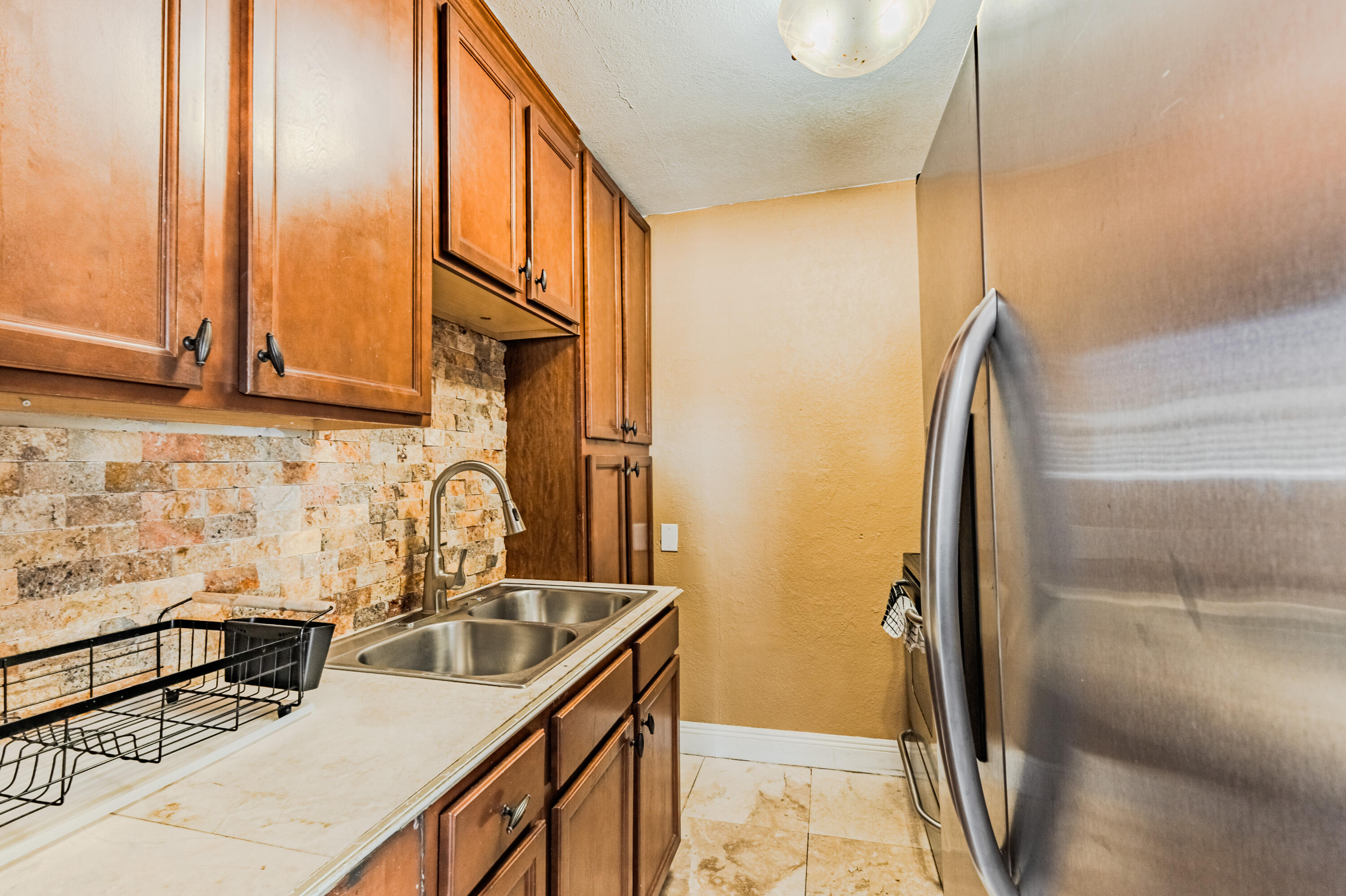 112 West 34th Street, Unit 1 Riviera Beach, FL 33404 - Photo 19 of 27 a kitchen with stainless steel appliances granite countertop a sink a stove and a refrigerator