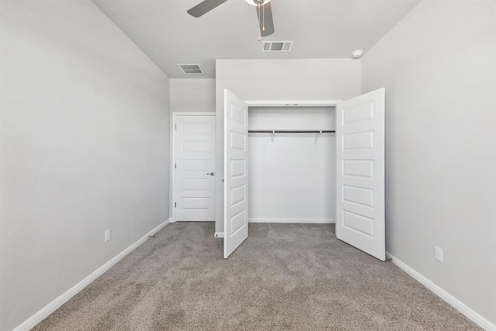 181 Old Town Road Kyle, TX 78640 - Photo 23 of 32 Plush carpeting and an integrated closet with double doors define this versatile bedroom.