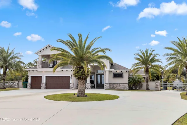 a front view of house with yard and palm tree