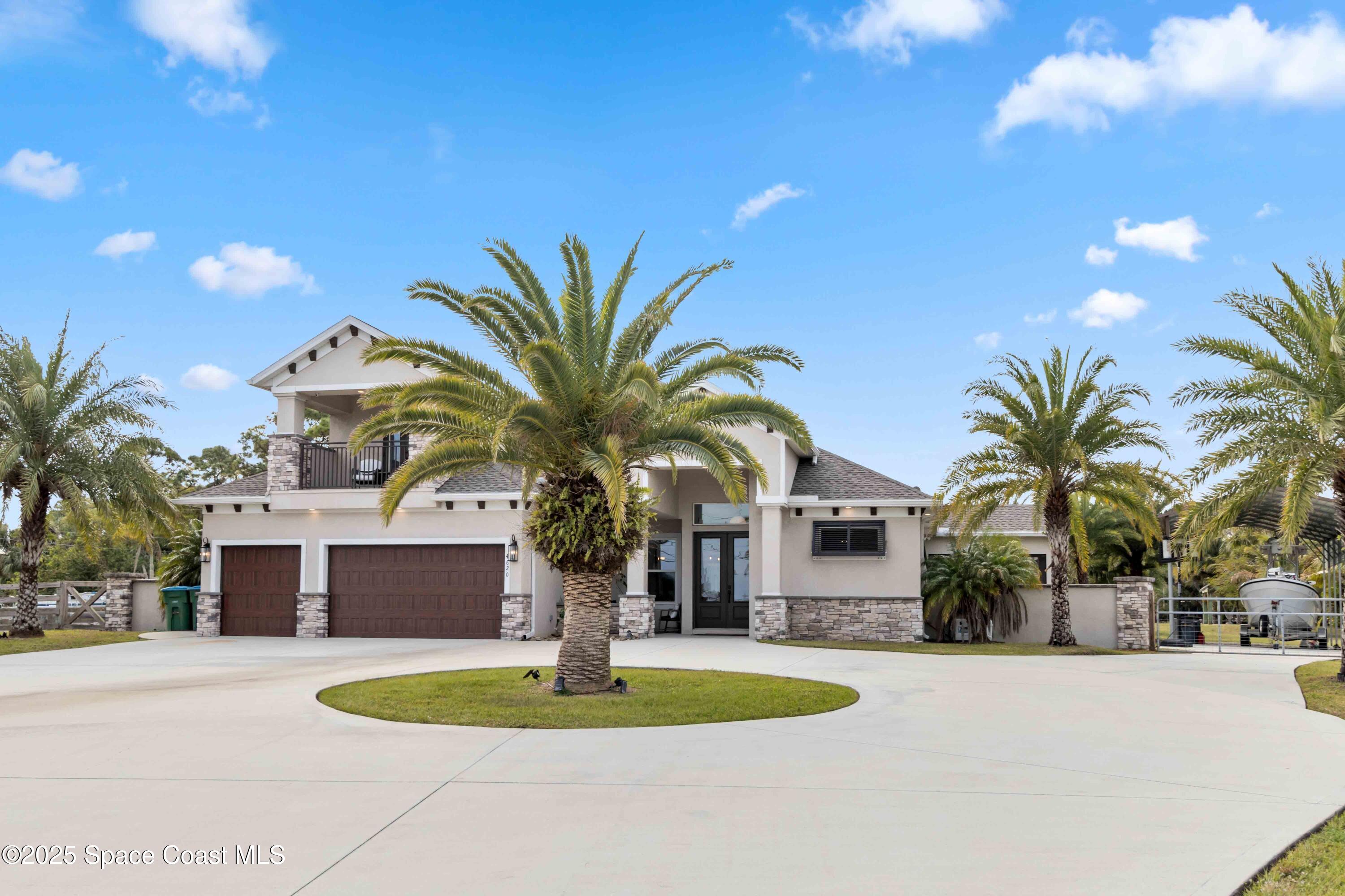 a front view of house with yard and palm tree