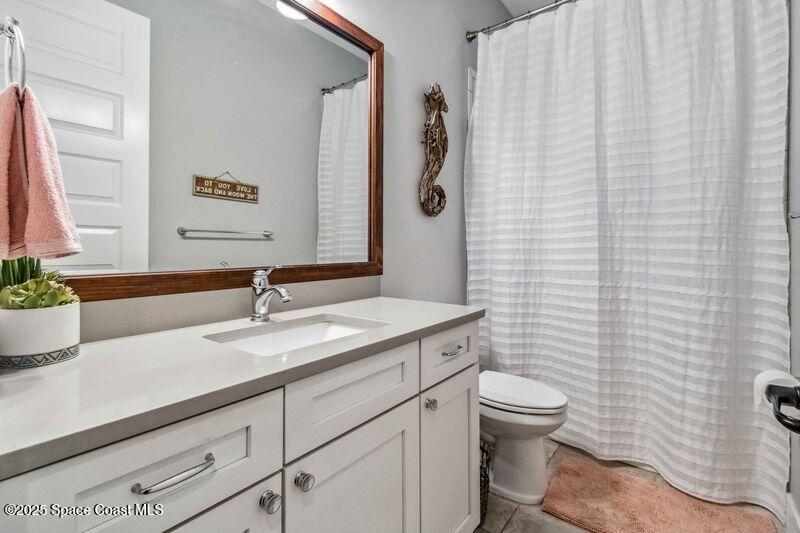 4620 Highway 1 Grant, FL 32949 - Photo 35 of 65 a bathroom with a granite countertop sink a toilet and a mirror