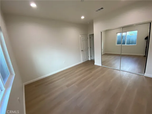 an empty room with wooden floor and mirror