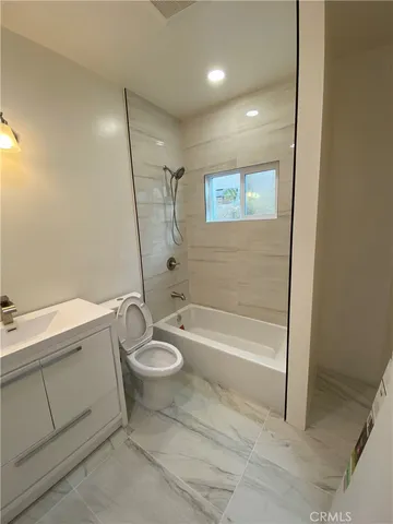 a bathroom with a granite countertop sink toilet and bathtub