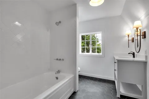 a bathroom with a bathtub sink and window