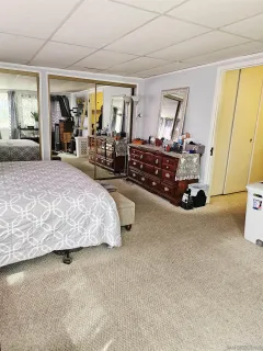 a bedroom with bed and large windows