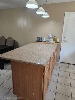 a kitchen with granite countertop a sink a stove top oven and cabinets