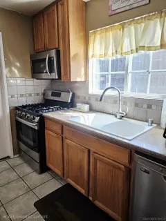 a kitchen with stainless steel appliances a stove sink and microwave