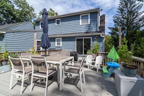 a view of a patio with table and chairs potted plants and a large tree