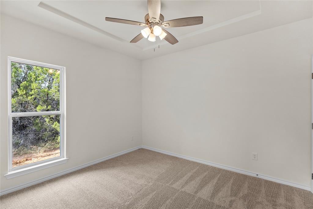 123 Cedar Shadow Lane Whitney, TX 76692 - Photo 21 of 27 an empty room with a window and a fan