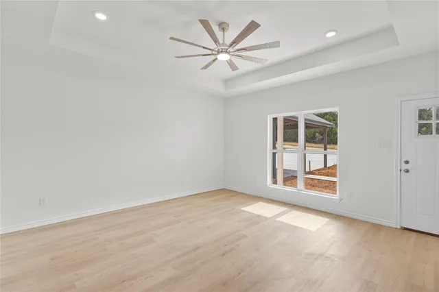 a view of a big room with wooden floor windows and a kitchen